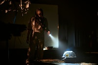 a man standing in a dark room with a flashlight