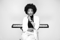 a black and white photo of a woman sitting on a keyboard