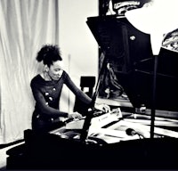 a black and white photo of a woman playing a piano
