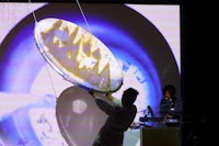 a man is holding a plate in front of a projection screen