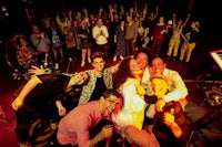 a group of people posing for a photo on stage