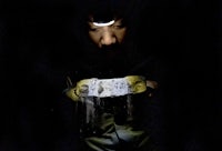 a man holding a piece of paper in the dark