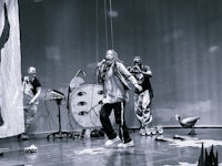 a black and white photo of a group of people on stage