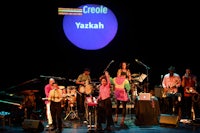 a group of people on stage with a sign that says yasakh
