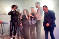 a group of people standing on stage with microphones